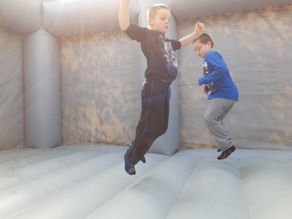 Zwei Schüler hüpfen in einer Hüpfburg