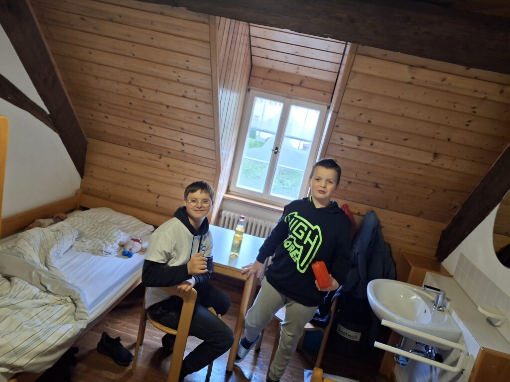 zwei schüler zeigen ihr Zimmer in der Unterkunft