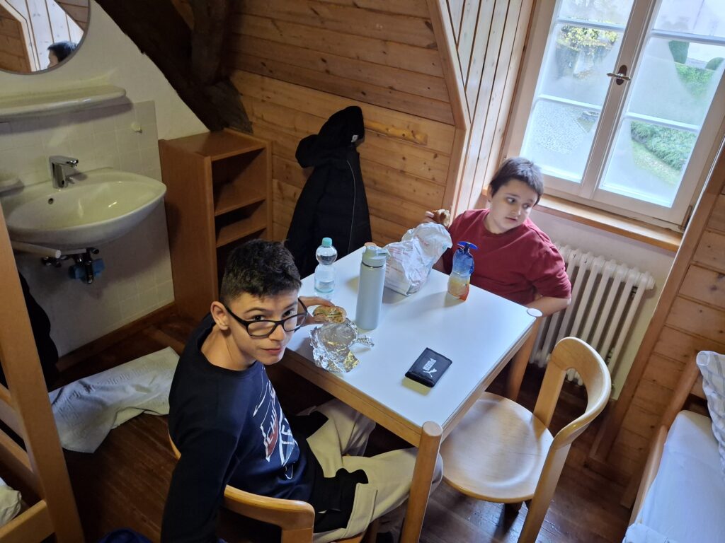 Zwei Schüler sitzen am Tisch in ihrem Zimmer und essen ihr Vesper