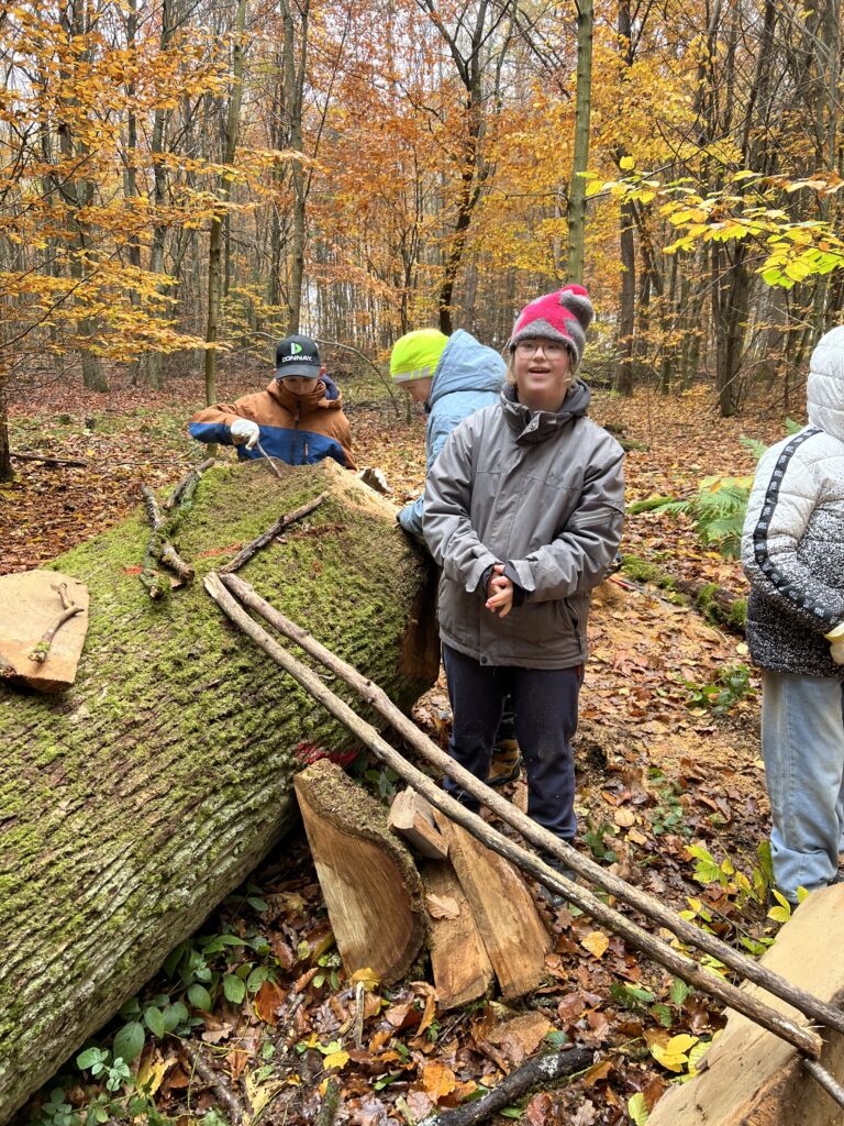 SchülerInnen zeigen ihre Murmelbahn aus Naturmaterialien