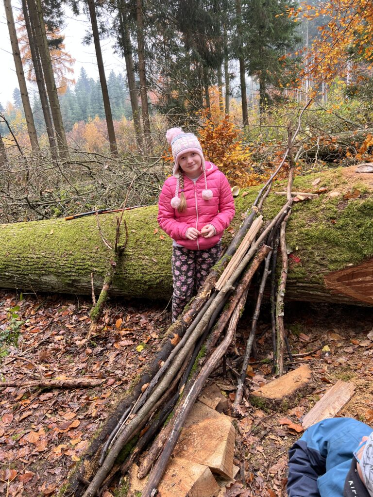 Eine Schülerin zeigt ihre Murmelbahn aus Naturmaterialien