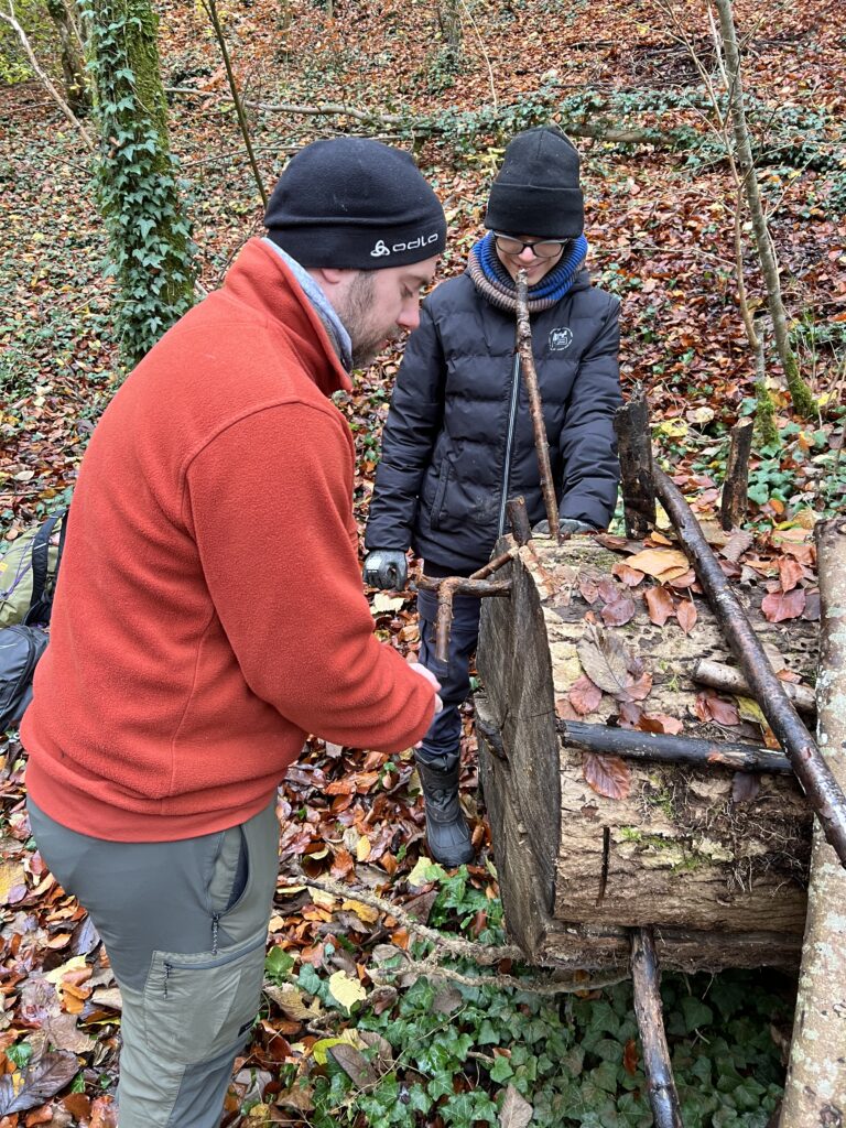 Ein Schüler baut mit einem Lehrer einen Bogen 