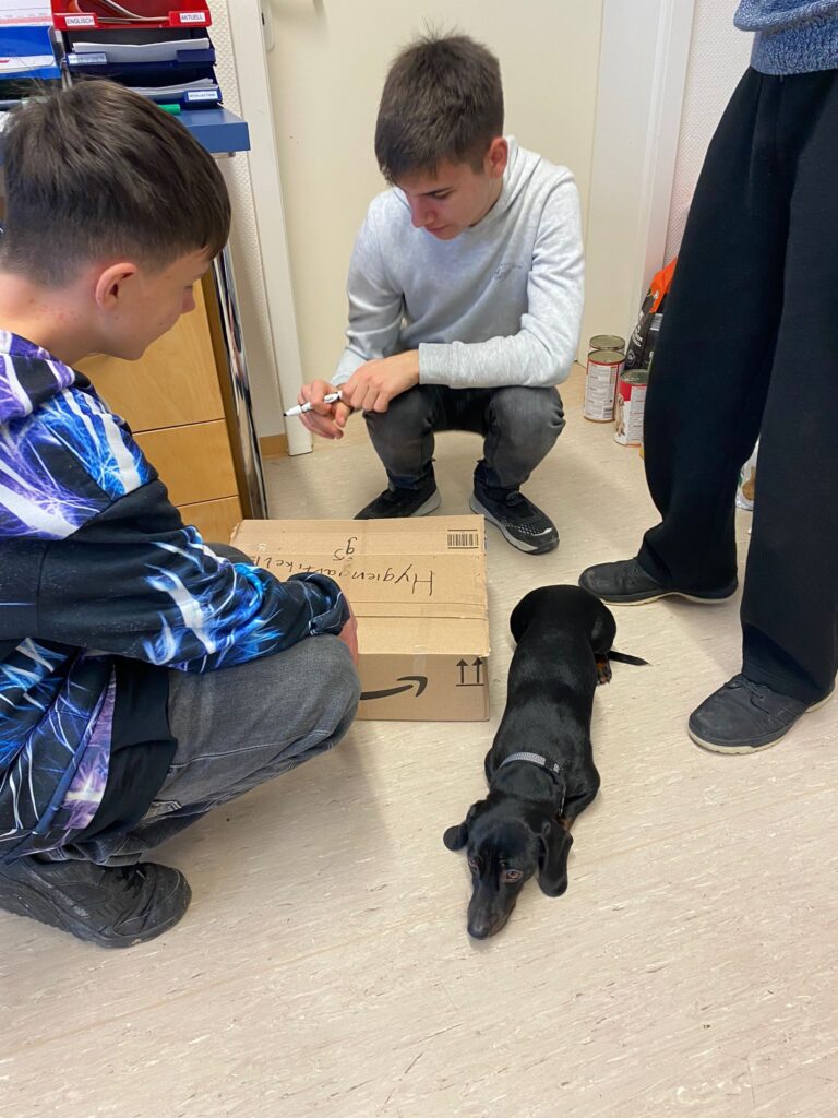 Schüler verpacken Spenden in einem Karton 