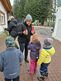 Eine Schülerin übergibt das Geschenk an die Baumschule Bob