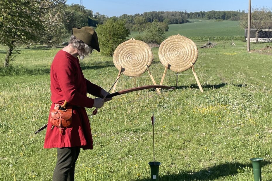 verkleideter Mann bereitet Bogenschießen vor