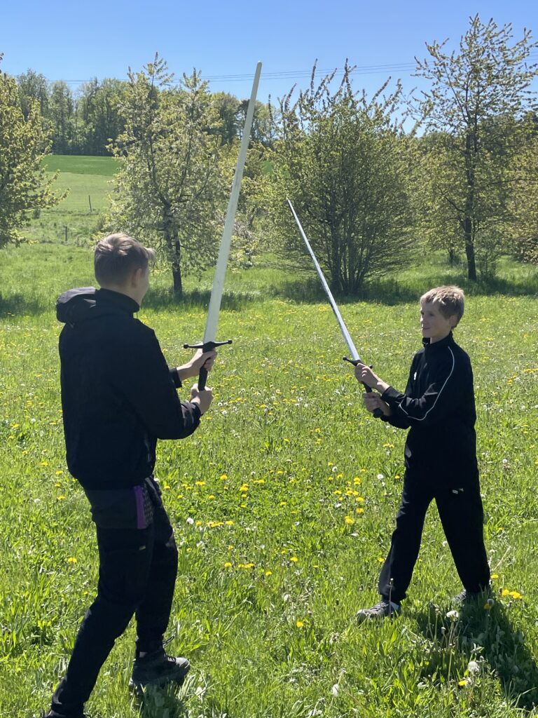 Zwei Schüler kämpfen mit Schwertern
