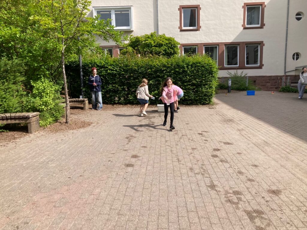 SuS rennen im Pausenhof an einer Wasserstation