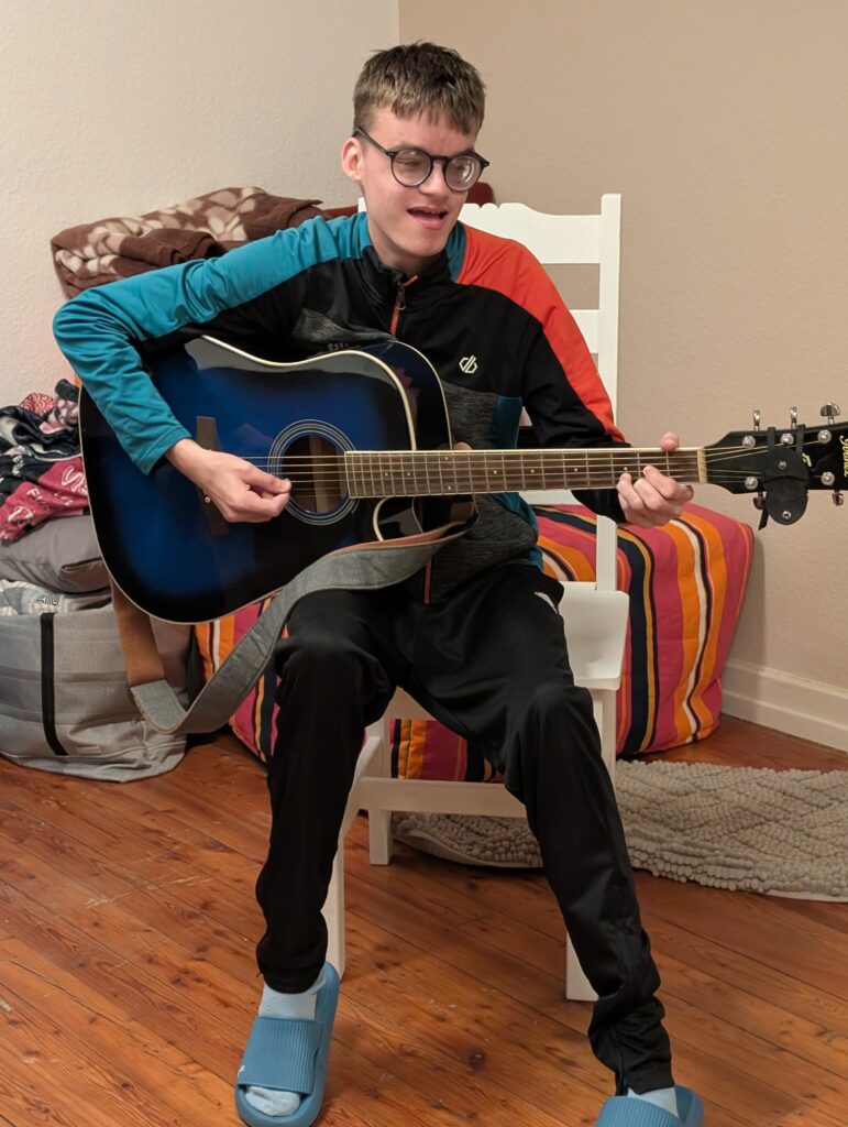 Ein Schüler spielt Gitarre und singt 