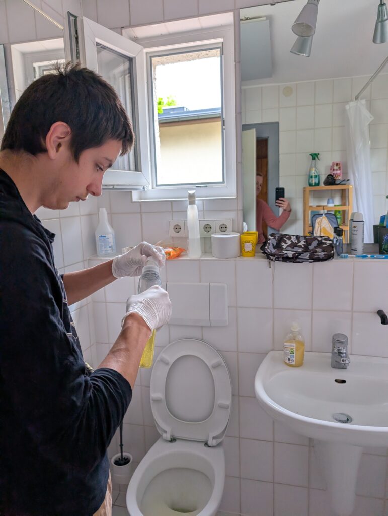 Ein Schüler reinigt das Badezimmer