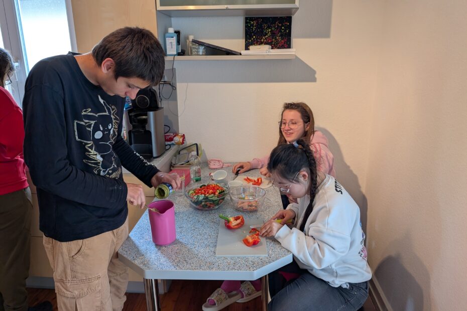 SuS sitzen am Tisch und schneiden Gemüse für das Abendessen